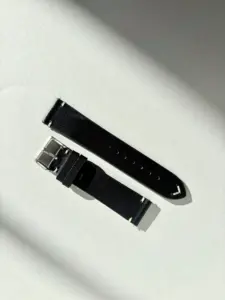 Vintage black leather watch strap in sunlight against a colored background by vild Hamburg