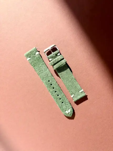 Vintage green suede watch strap in sunlight against a colored background by vild Hamburg