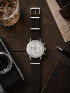 Dunkelbraunes Leder NATO Strap von vild Hamburg, montiert an einer Breitling Navitimer Ref. A23322 und von oben mit stilvoller Dekoration fotografiert