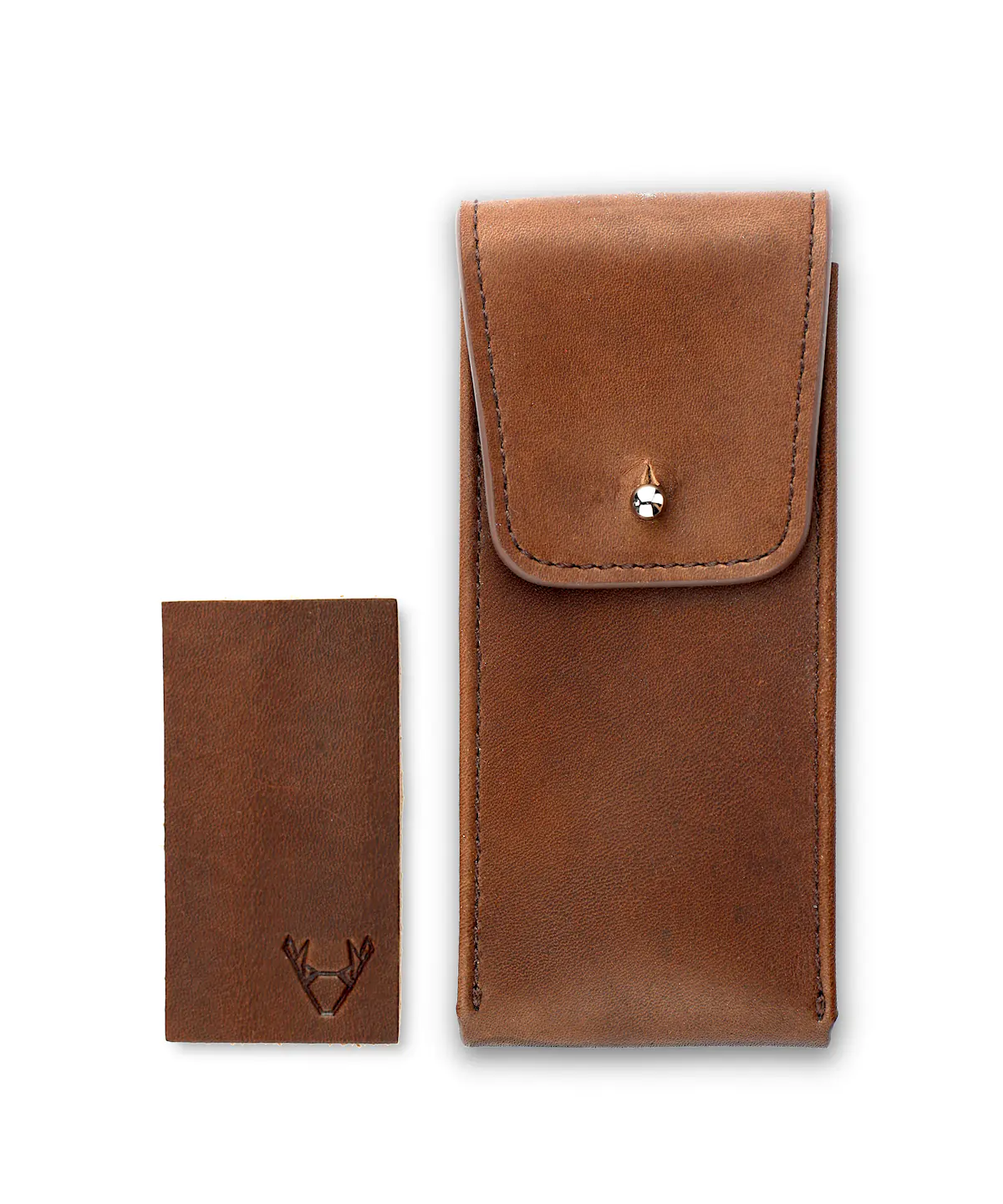 Brown leather watch case with silver pin closure and leather patch lying next to it on a white background