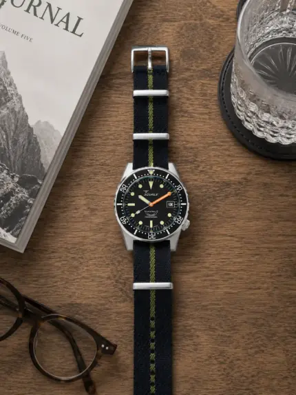 Dunkelblau grün gestreiftes Tudor NATO Strap von vild Hamburg, montiert an einer Squale 1521 Militaire Taucheruhr und von oben mit Dekoration gezeigt