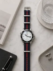 Dunkelblau rot gestreiftes Tudor NATO Strap von vild Hamburg, montiert an einer Omega Seamaster Diver 300M und dekorativ von oben aufgenommen