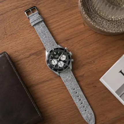 Grey melange canvas watch strap by vild Hamburg, mounted on a TAG Heuer Autavia Heritage and shown decoratively from above.