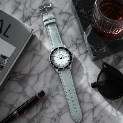 Grey and blue leather strap from vild Hamburg, mounted on a Sinn 104 and photographed decoratively from above.