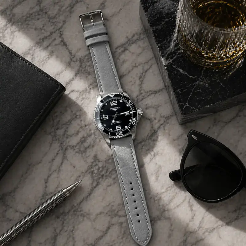 Lederarmband Grau von vild Hamburg, an einer Longines HydroConquest montiert und von oben mit passender Dekoration gezeigt