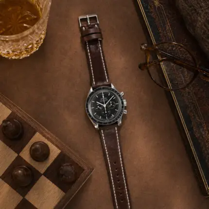 Coffee-colored leather strap by vild Hamburg, mounted on an Omega Speedmaster Moonwatch and shown from above with decoration
