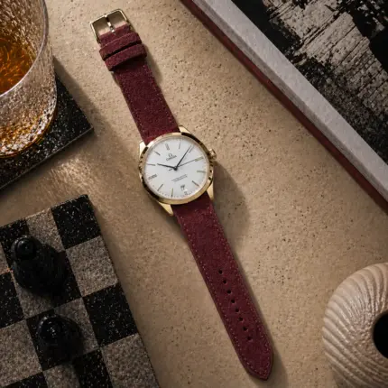 Suede strap in Bordeaux by vild Hamburg, mounted on an Omega De Ville Tresor and photographed decoratively from above.