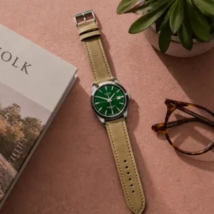 Green and brown leather strap by vild Hamburg, mounted on a Tissot Gentleman watch and shown decoratively from above.