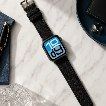 Apple Watch Canvas Band in black by vild Hamburg, mounted on the Apple Watch and shown from above with matching decoration