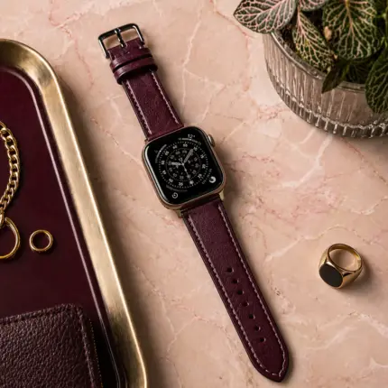 Apple Watch Lederarmband beere von vild Hamburg, montiert an der Uhr auf dekoriertem Marmortisch von oben fotografiert