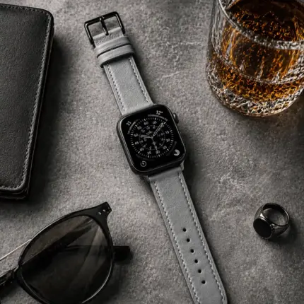 Apple Watch Lederarmband grau von vild Hamburg, montiert an der Uhr mit Sonnenbrille und Dekoration von oben