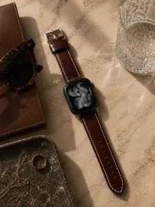 Apple Watch Lederarmband kaffee braun von vild Hamburg, an der Uhr montiert und von oben auf Marmortisch fotografiert