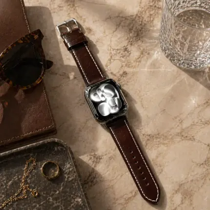 Apple Watch Lederarmband kaffee braun von vild Hamburg, an der Uhr montiert und von oben auf Marmortisch fotografiert