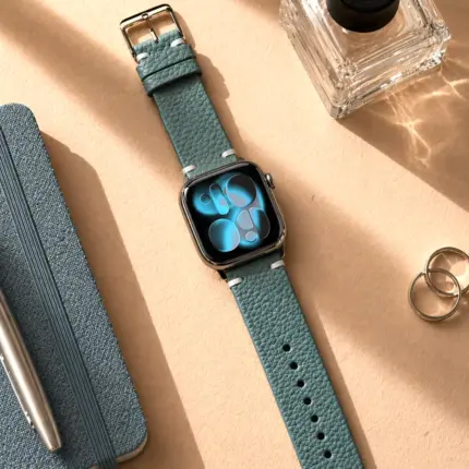 Apple Watch Vintage leather strap in petrol blue by vild Hamburg, mounted on the watch and shown in a decorated top view.