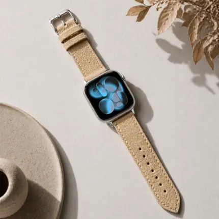 Apple Watch suede strap in beige by vild Hamburg, mounted on the watch and shown decoratively from above.