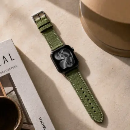 Apple Watch suede strap in spruce green by vild Hamburg, mounted on the watch with matching decoration in the top view.