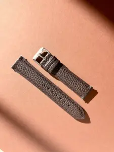 leder uhrarmband dunkelbraun im Sonnenlicht auf farblichem Hintergrund von vild Hamburg
