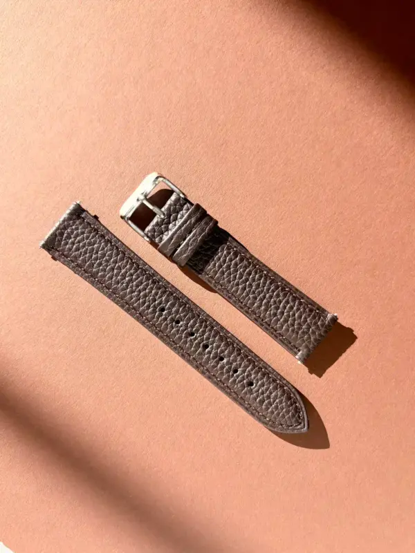 leder uhrarmband dunkelbraun im Sonnenlicht auf farblichem Hintergrund von vild Hamburg