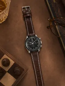 Lederarmband Kaffee von vild Hamburg, an einer Omega Speedmaster Moonwatch montiert und von oben mit Dekoration gezeigt