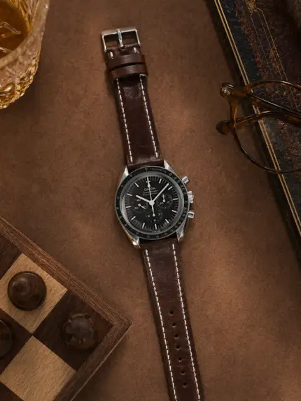 Coffee-colored leather strap by vild Hamburg, mounted on an Omega Speedmaster Moonwatch and shown from above with decoration