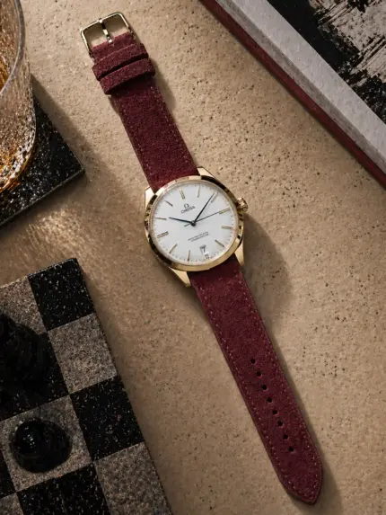 Suede strap in Bordeaux by vild Hamburg, mounted on an Omega De Ville Tresor and photographed decoratively from above.