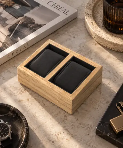 Wooden clock holder in oak brown and 2 dark grey cushions on a stone table with decoration.