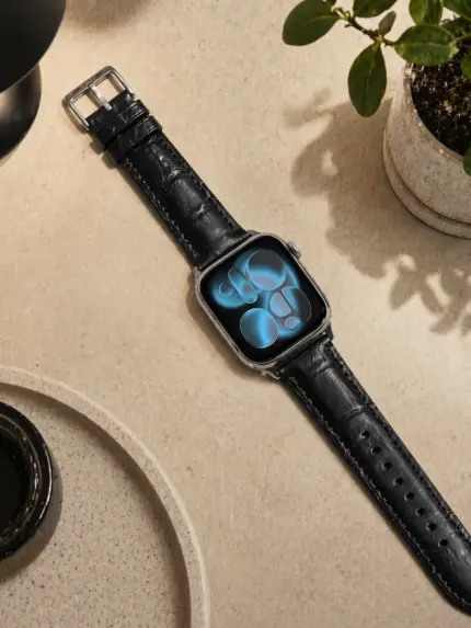 Apple Watch Kroko Lederarmband schwarz von vild Hamburg, an der Uhr montiert und von oben auf dekoriertem Motivset fotografiert