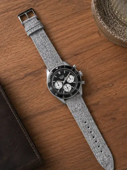 Grey melange canvas watch strap by vild Hamburg, mounted on a TAG Heuer Autavia Heritage and shown decoratively from above.