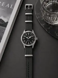 Dunkelgraues Premium NATO Strap von vild Hamburg, montiert an einer IWC Pilot’s Watch Mark XVIII und von oben mit passender Dekoration aufgenommen