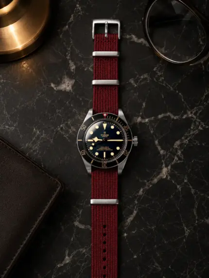 Dark red premium NATO strap from vild Hamburg, mounted on a Tudor Black Bay and photographed decoratively from above.