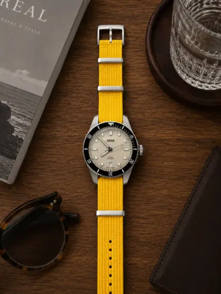 Gelbes Premium NATO Strap von vild Hamburg, montiert an einer Oris Divers Sixty-Five und von oben dekorativ gezeigt