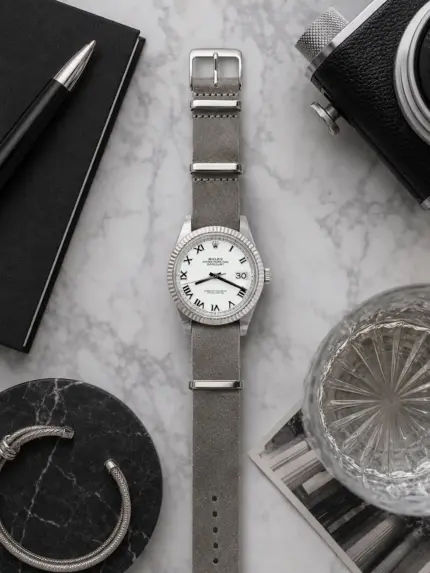 Sterling graues Leder NATO Strap von vild Hamburg an einer Rolex Datejust 41 Ref. 126334 White Roman, von oben mit Buch und passender Dekoration aufgenommen