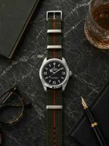 Aldo NATO strap, green and red striped, by vild Hamburg, mounted on a Rolex Explorer and shown decoratively from above.