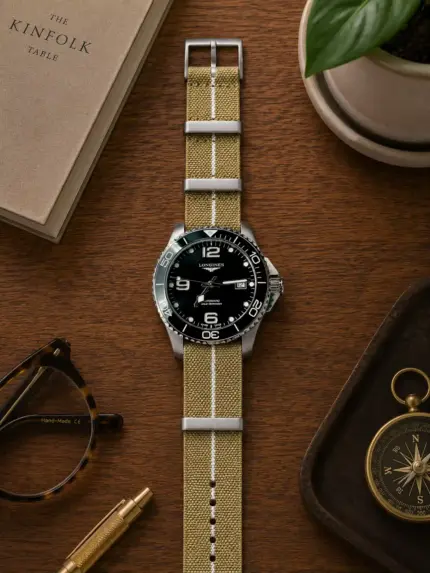 Khaki weiß gestreiftes Textil NATO Strap von vild Hamburg an einer Longines HydroConquest Taucheruhr, von oben mit passender Dekoration fotografiert