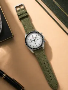 Wildlederarmband Grün von vild Hamburg, an einer Omega Speedmaster Moonwatch montiert und von oben mit Dekoration gezeigt