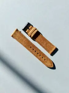 wildleder uhrarmband bernstein im Sonnenlicht auf farblichem Hintergrund von vild Hamburg