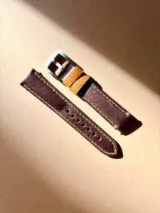 leder uhrarmband rustikal braun im Sonnenlicht auf farblichem Hintergrund von vild Hamburg