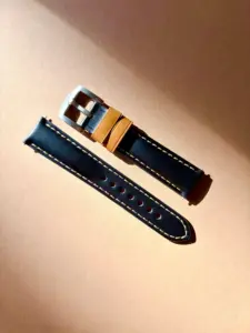 leder uhrarmband rustikal schwarz im Sonnenlicht auf farblichem Hintergrund von vild Hamburg