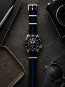 Schwarz blau gestreiftes Textil NATO Strap von vild Hamburg an einer Seiko Marinemaster Prospex SLA079, von oben mit passender Schreibtisch-Dekoration aufgenommen