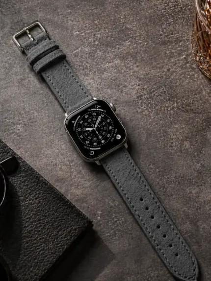 Apple Watch Wildleder Armband dunkelgrau von vild Hamburg, an der Uhr montiert und von oben mit passender Dekoration gezeigt