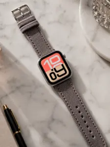 Apple Watch Canvas Band grey beige by vild Hamburg, mounted on the watch in a decorated top view.