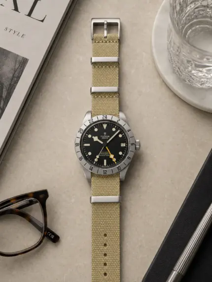 Sand beige Premium Textil NATO Strap von vild Hamburg an einer Tudor Black Bay Pro, stilvoll von oben mit Accessoires fotografiert