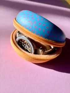 Watch case for 1 o'clock in a blue donut design with pink sprinkles, with watch inserted.