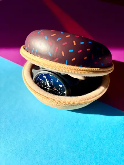 Watch case for 1 watch in a brown donut design with colorful sprinkles, containing an IWC Pilot's Watch.