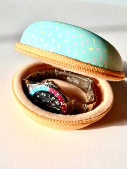 Watch case for 1 watch in a light green donut design with colorful sprinkles, containing a vintage Rolex Pepsi.