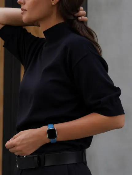 Frau in Navy Rollkragen Longsleve und dunkelblauer Hose trägt eine silberne Apple Watch mit blauem Lederarmband von vild.