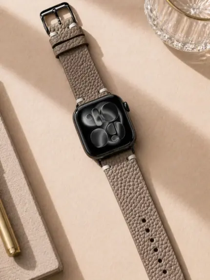 Apple Watch vintage leather strap, grey and beige, by vild Hamburg, mounted on the watch and shown from above with decoration.