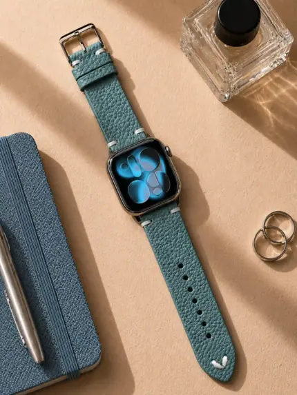 Apple Watch Vintage leather strap in petrol blue by vild Hamburg, mounted on the watch and shown in a decorated top view.