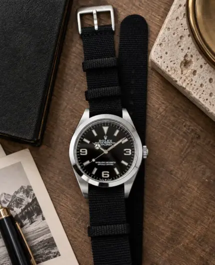 Textile NATO strap ONYX in black by vild, mounted on a Rolex Explorer and shown from above with matching table decoration