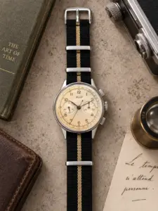 Premium NATO Strap ASCOT in Schwarz und mit beige Streifen von vild, an einem Tissot Vintage Chronograph montiert und von oben mit passender Tischdekoration gezeigt